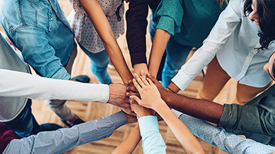 top angle shot of a group of people's hands coming together.